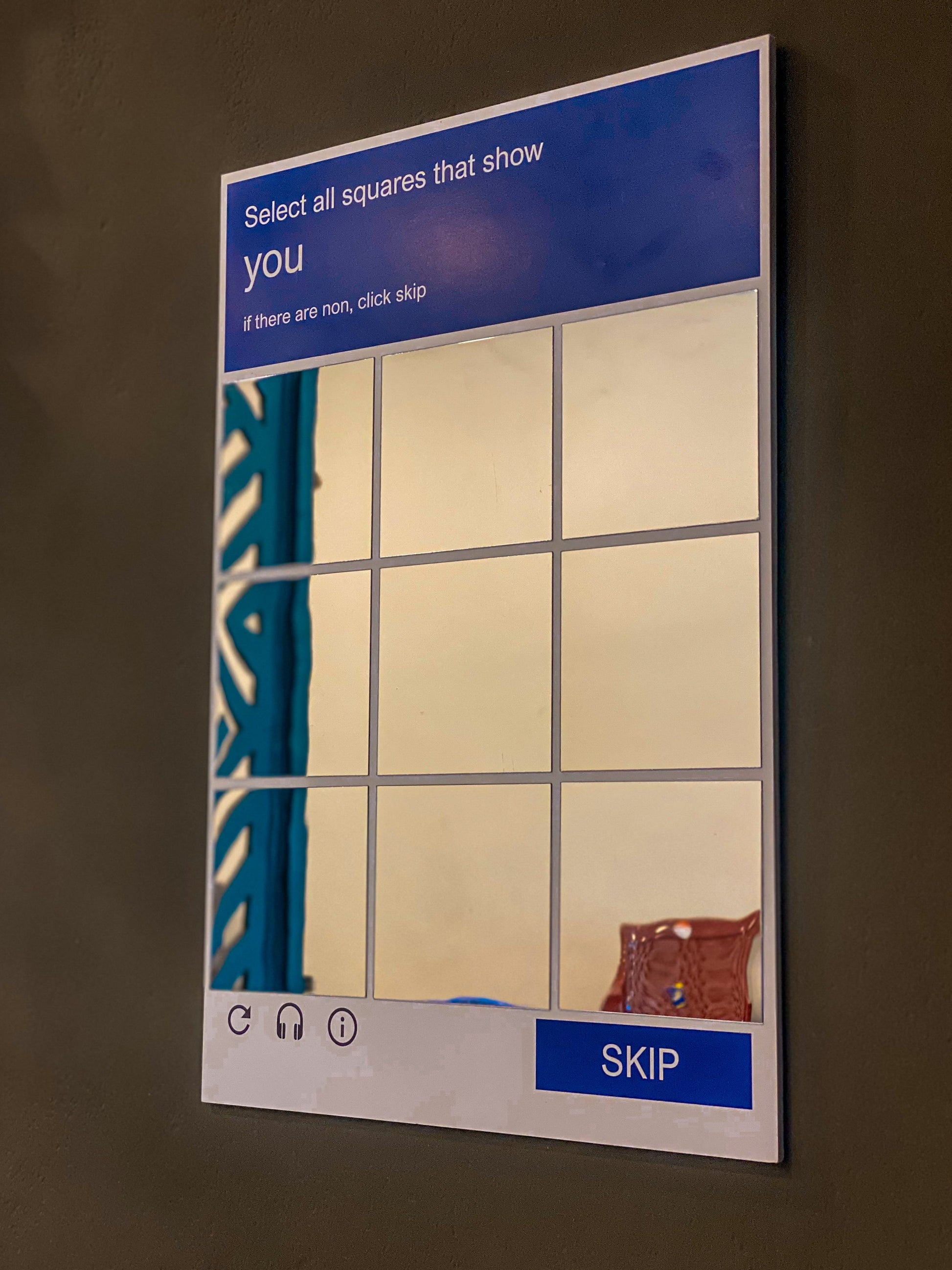 CAPTCHA wall mirror close-up showing select all squares grid design, silver acrylic novelty mirror